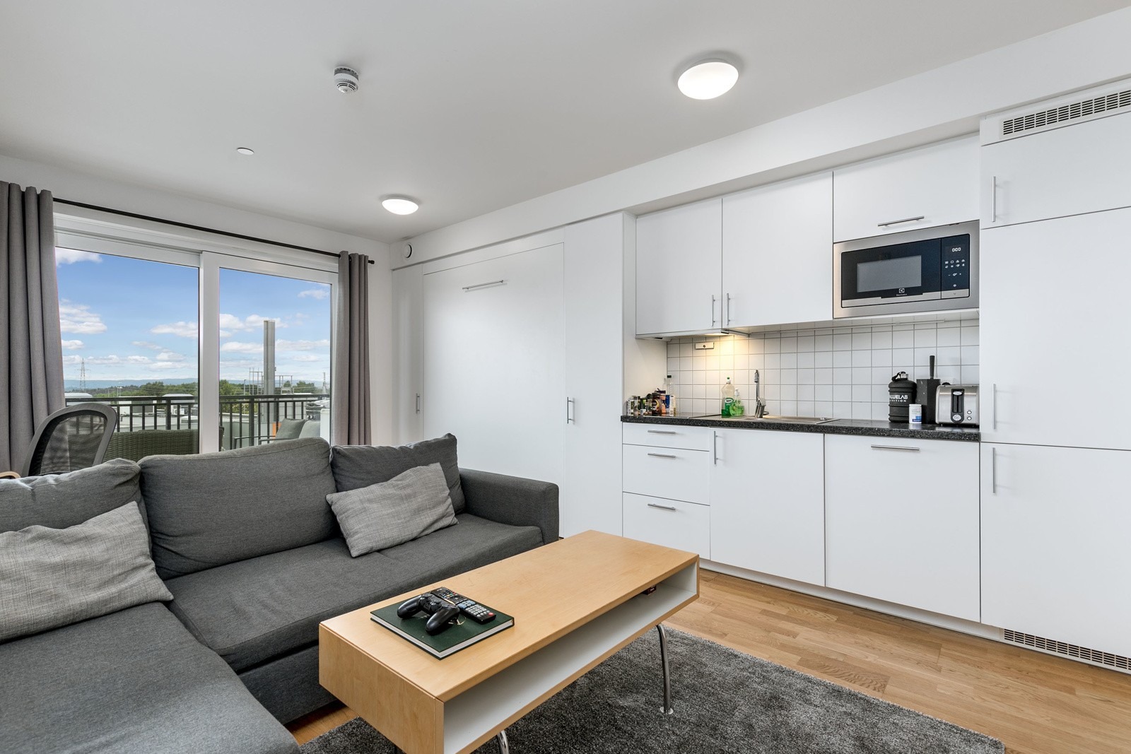 Stuen fremstår som svært innbydende i lyse, delikate fargevalg. På gulvet er det lagt trestavs eikeparkett som strekker seg sømløst gjennom leiligheten.